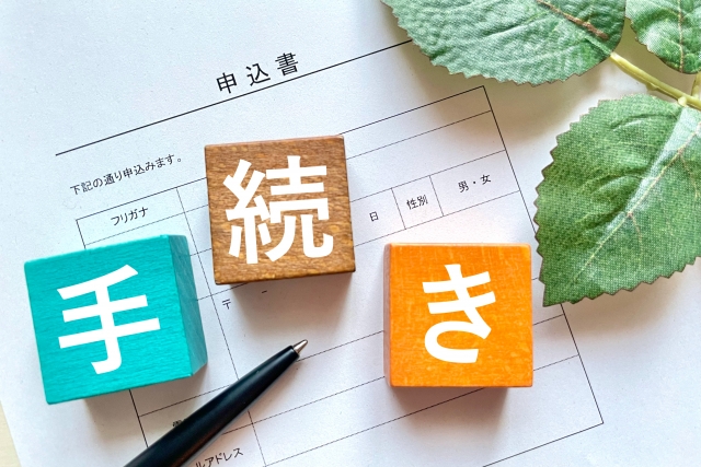 手続きと書かれたブロックと申込書