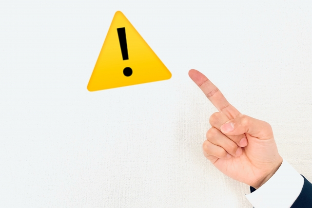 注意マークを指さす手