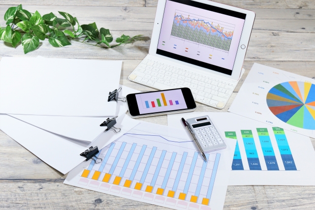 不動産価格推移に関するデータとパソコン